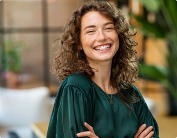 Smiling woman with curly hair and green blouse