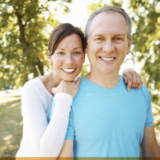 Man and woman smiling together in a forest