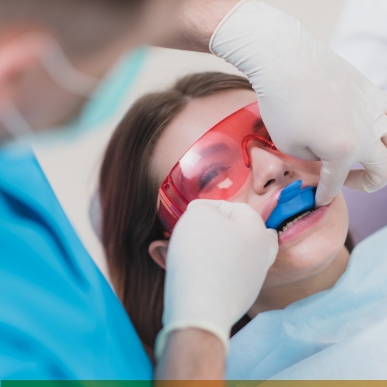 Dental patient with teeth whitening trays on her teeth