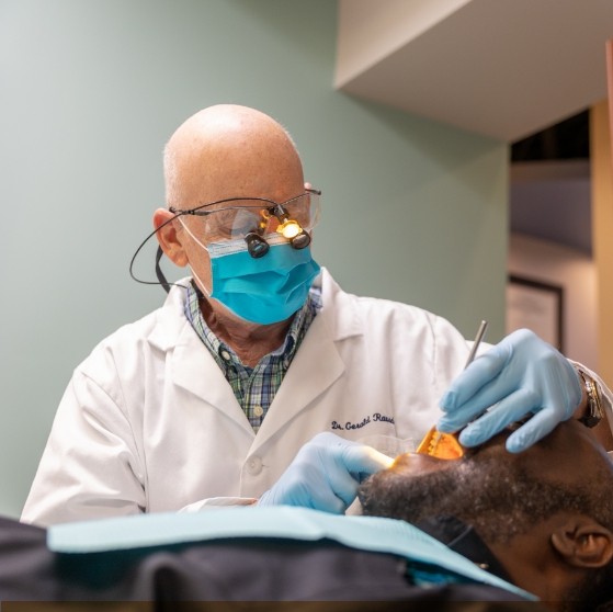 Dentist examining a patient with dental implants in Stone Mountain