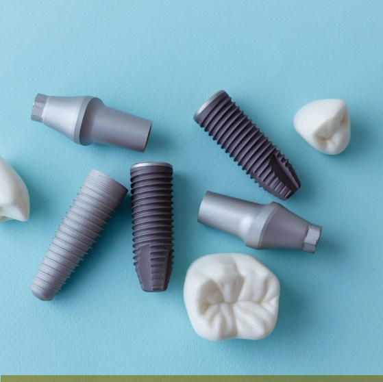 Several dental implants and crowns against light blue background