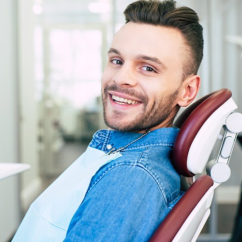 Patient smiling while sitting in treatment chair