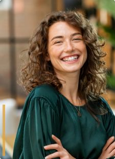 Smiling woman with curly brown hair and green blouse