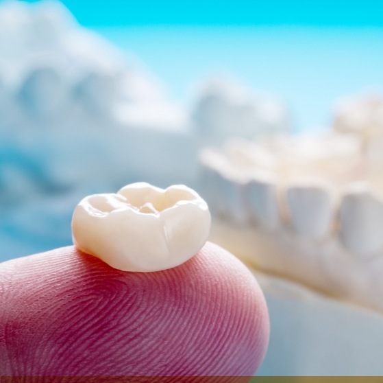 Dental crown resting on a finger